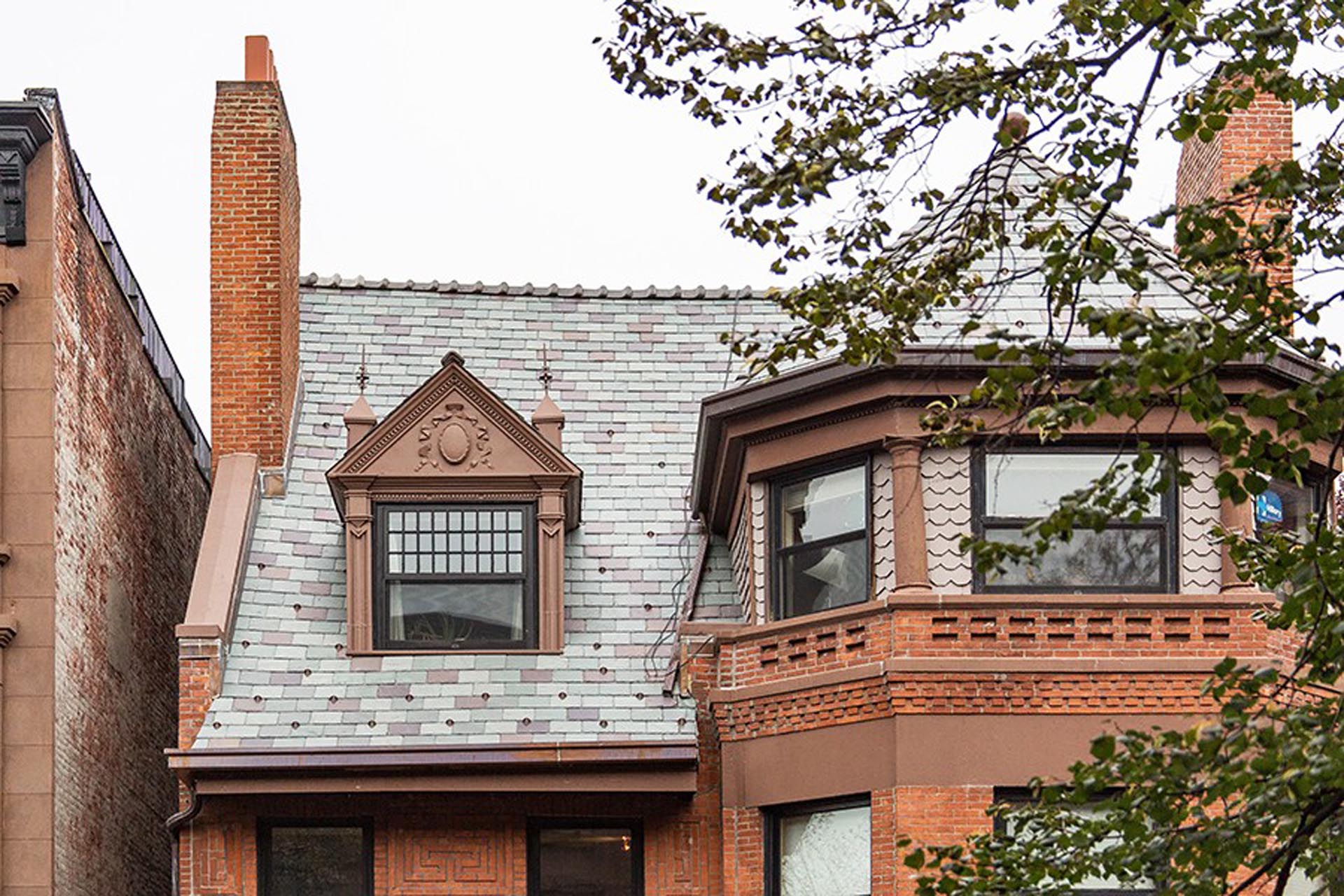 <p>The building’s most distinctive features includes a wood-shingled faceted turret which sits atop a three-sided corner bay; a delicate pedimented dormer; and gable, tower, and mansard slate roofs.</p>
