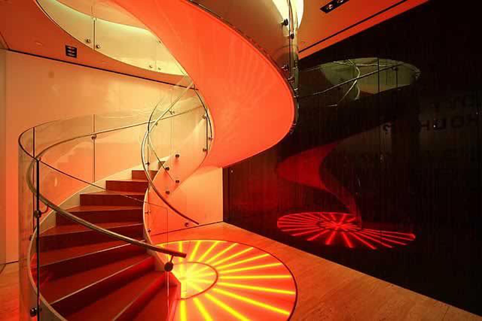 <p>An LED-lit spiral staircase leads to an exhibition space.</p>

