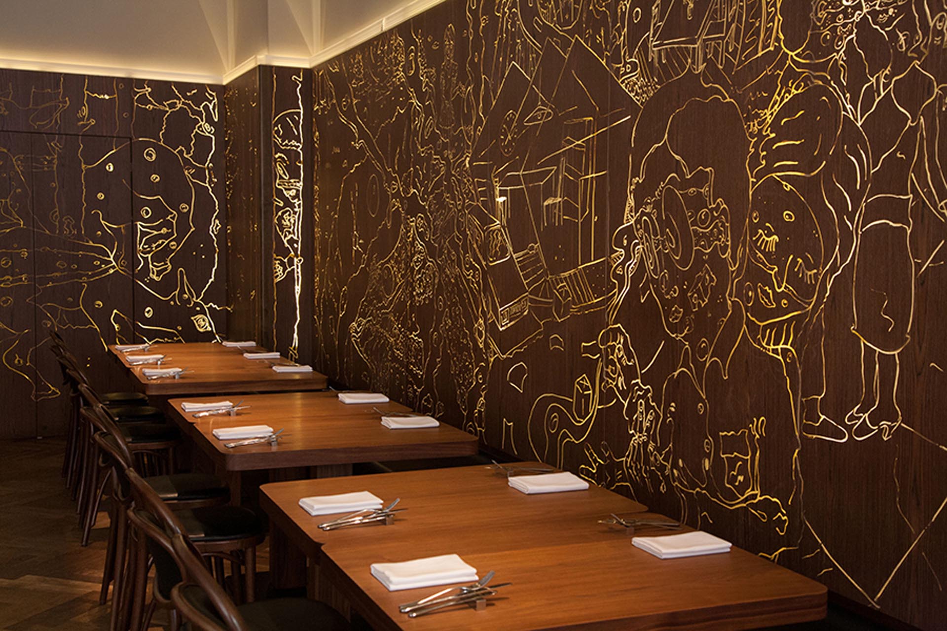 <p>Black wooden panels along the walls are backlit to illuminate engraved graffiti.</p>

