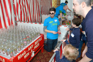 RAND Project Associate Michael Langwell explains Ring Toss to the eager children. (In the far background Samuel Jacobs mans another booth.)